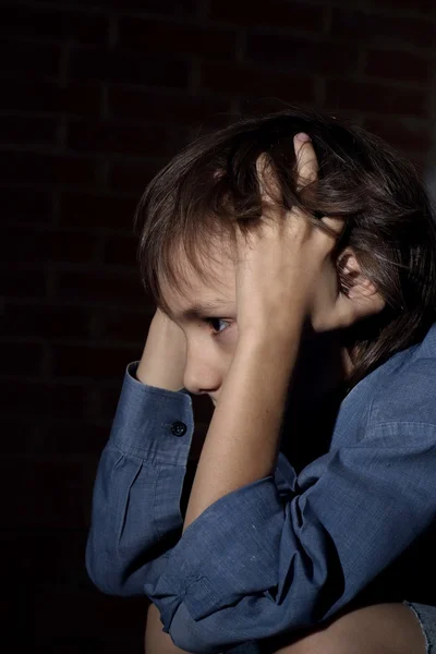 Schöner trauriger Junge sitzt — Stockfoto