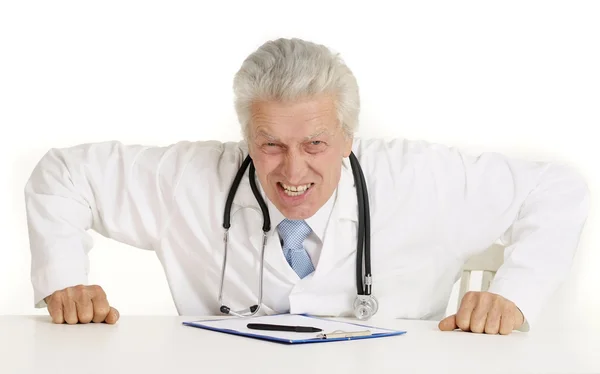 Angry doctor at a table — Stock Photo, Image