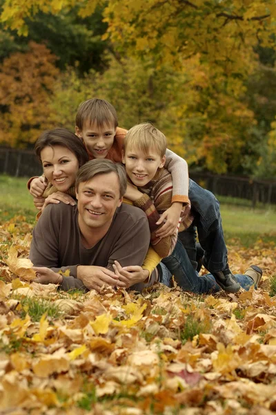 Familia acostada en el parque de otoño — Foto de Stock