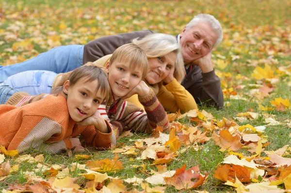 Bejaarde echtpaar en kinderen in de herfst park — Stockfoto