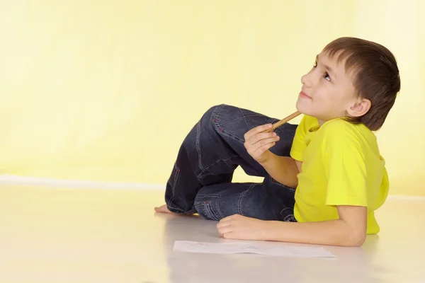 Nadenkend jongen in een geel t-shirt — Stockfoto