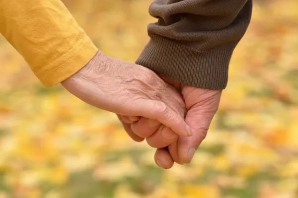 Elderly couple holding hands — Stock Photo, Image