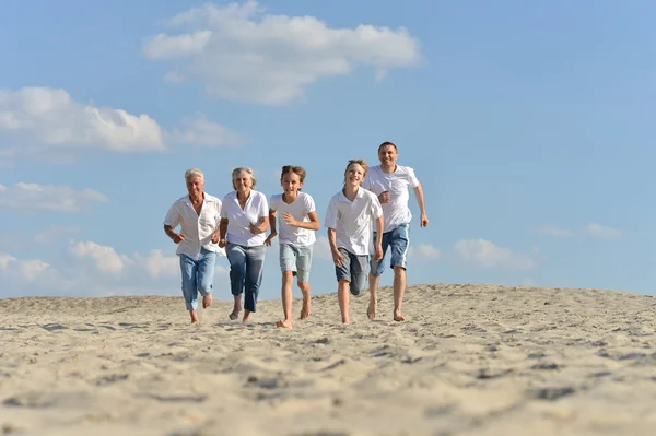 Familia feliz corriendo en una playa —  Fotos de Stock