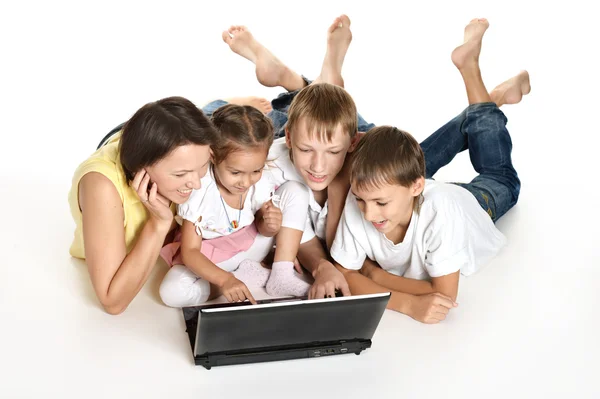 Família deitada em um chão com laptop — Fotografia de Stock