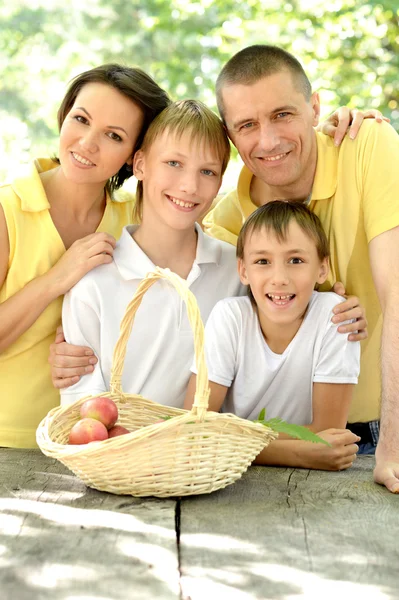 Happy family with a basket of fruit — Stock Photo, Image