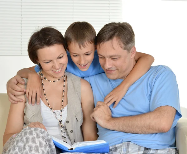 Família feliz lendo um livro — Fotografia de Stock