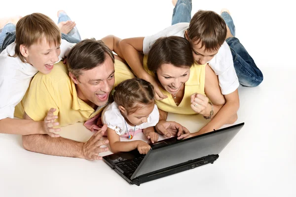 Família deitada em um chão com laptop — Fotografia de Stock