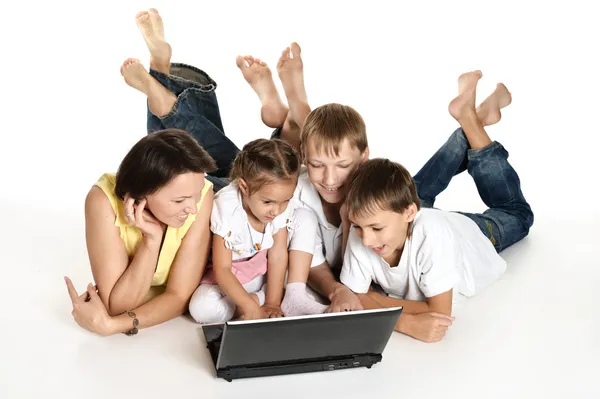 Famiglia sdraiata su un piano con computer portatile — Foto Stock