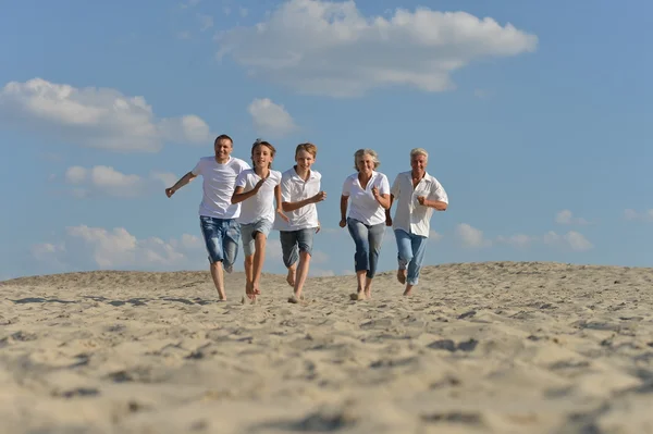 Ευτυχισμένη οικογένεια που τρέχει σε μια παραλία — Φωτογραφία Αρχείου