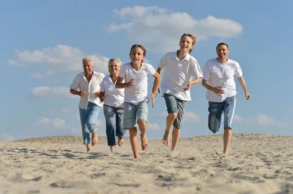 Familia feliz corriendo en una playa —  Fotos de Stock