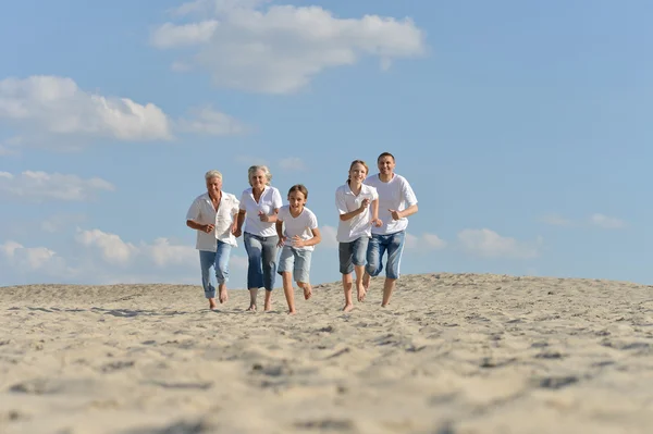 Happy family running on a beach — Stock Photo, Image