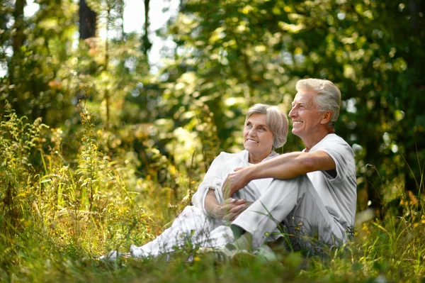 Das alte Paar sitzt im Gras — Stockfoto