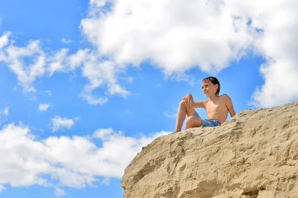 Boy sitting on a hill — 图库照片