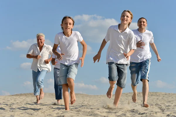 Glückliche Familie läuft am Strand — Stockfoto