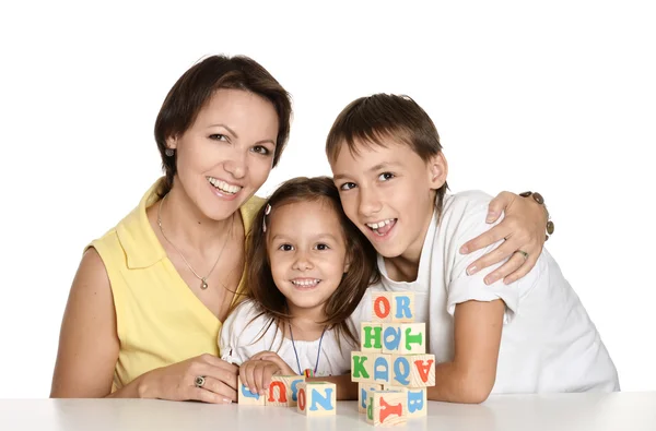 Moeder en haar kinderen spelen met kubussen — Stockfoto