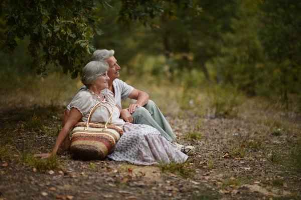 Elderly couple sitting outdoors — Stock Photo, Image