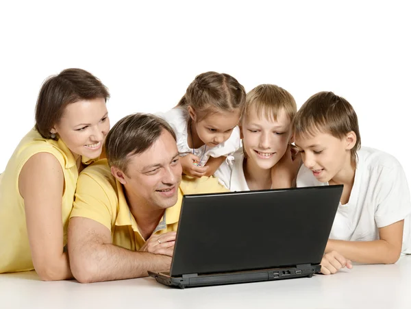 Famiglia sdraiata su un piano con computer portatile — Foto Stock