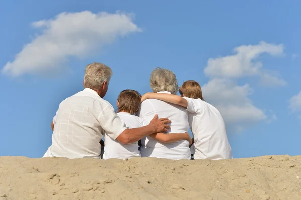 Большая счастливая семья отдыхает на песке вместе — стоковое фото
