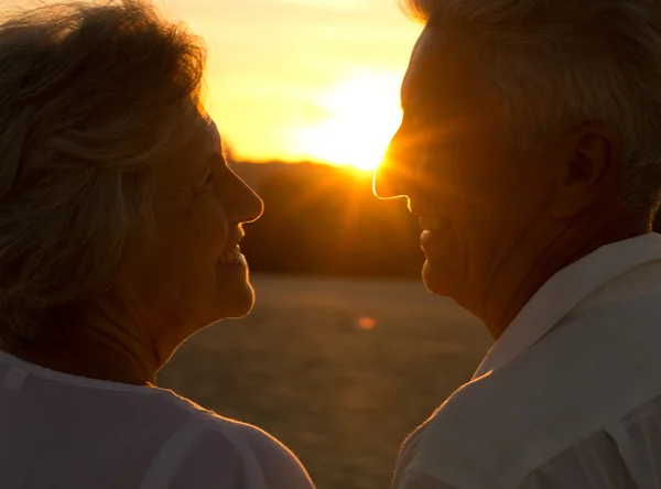 Bejaarde echtpaar bij zonsondergang — Stockfoto