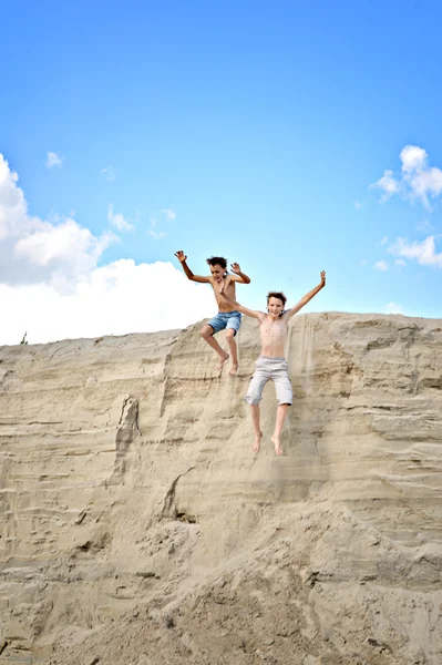 Due ragazzi che saltano da una collina — Foto Stock