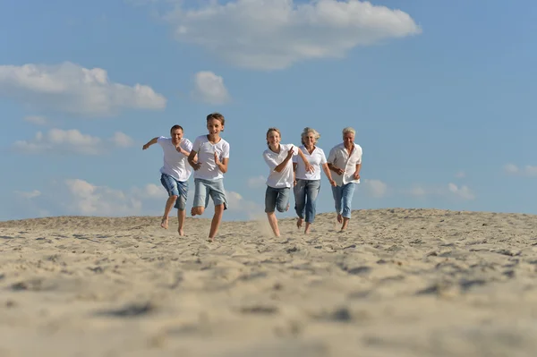 Familia feliz corriendo en una playa —  Fotos de Stock