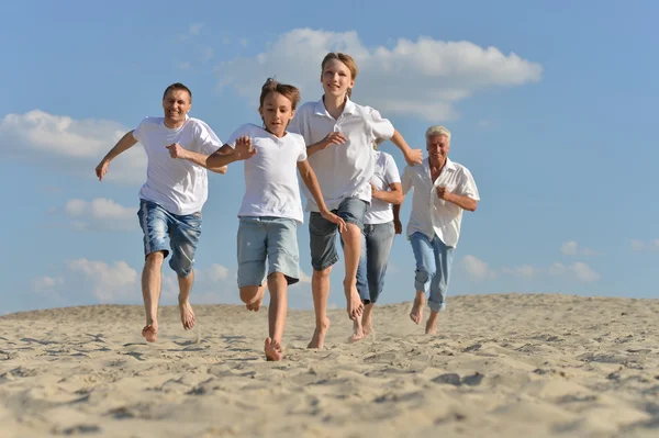 Ευτυχισμένη οικογένεια που τρέχει σε μια παραλία — Φωτογραφία Αρχείου