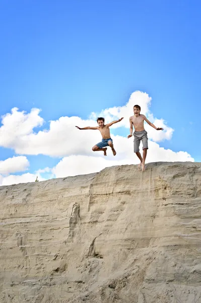 Två pojkar hoppa från en kulle — Stockfoto