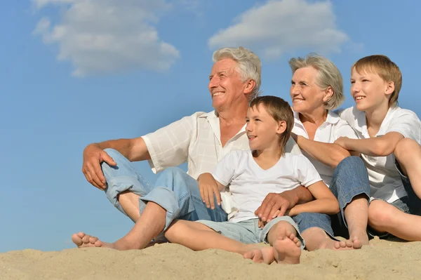 Grande família feliz relaxando na areia juntos — Fotografia de Stock