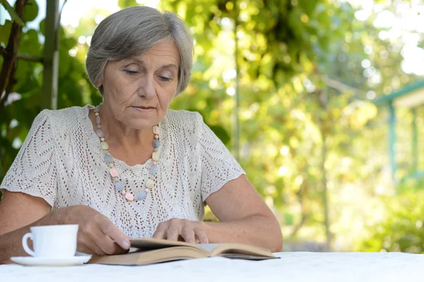 Vrouw leest aan tafel — Stockfoto