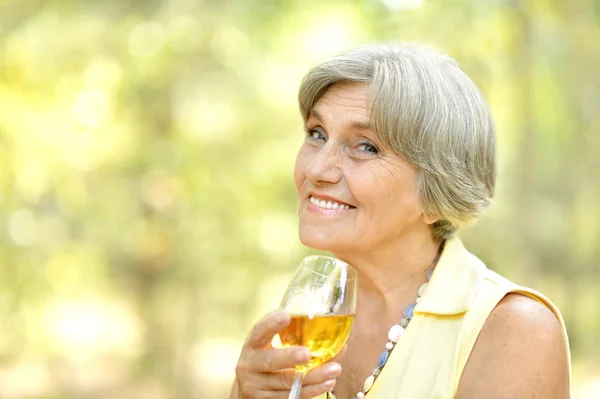 Ältere Frau trinkt im Sommer Wein — Stockfoto