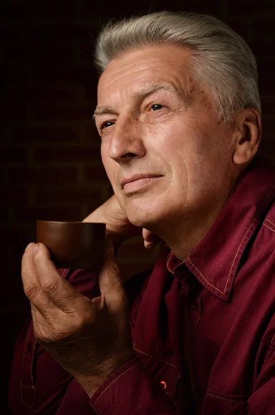 Homem idoso bebendo chá em um preto — Fotografia de Stock