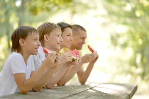 Föräldrar äter vattenmelon med barn — Stockfoto