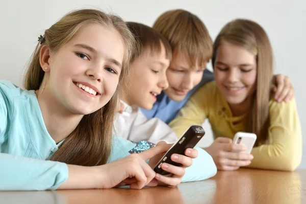 Vrolijke kinderen met een mobiele — Stockfoto