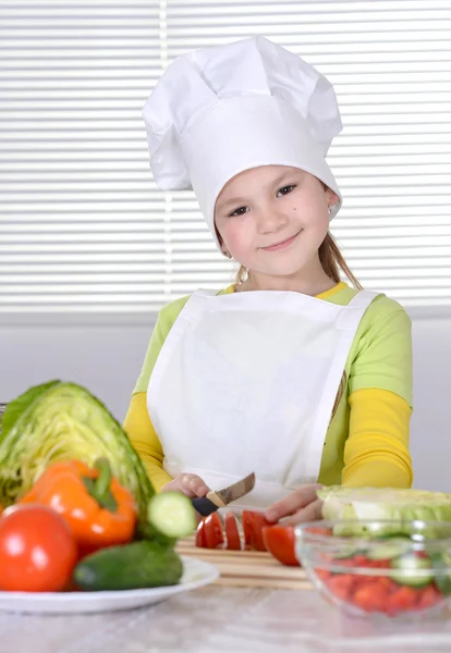 Klein meisje bereidt salade — Stockfoto