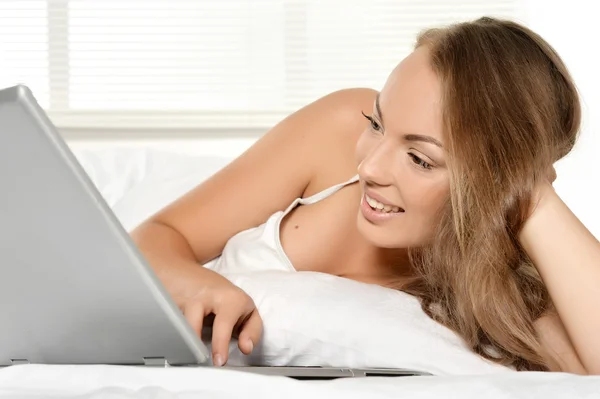 Κορίτσι με το laptop στο κρεβάτι — Φωτογραφία Αρχείου