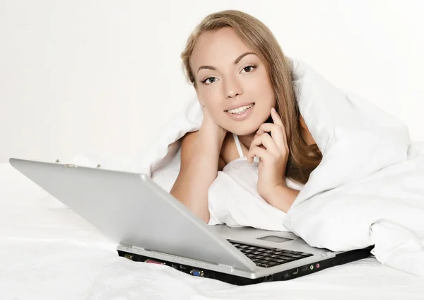 ベッドでノート パソコンを持つ少女 — ストック写真