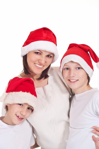 Мама з дітьми в капелюхах Санти — стокове фото