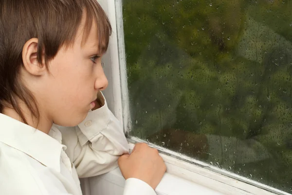 Soñando chico sentado en casa — Foto de Stock