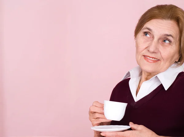 Beautiful Caucasian aged woman sitting with a cup — Stock Photo, Image