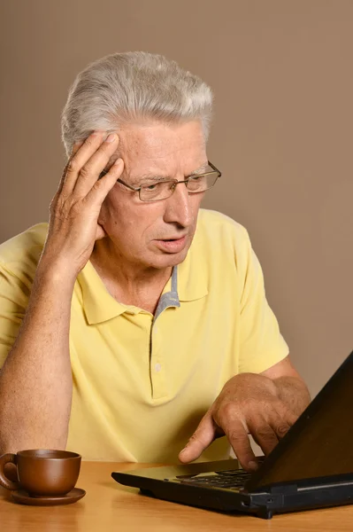 Elderly man with a laptop — Stock Photo, Image