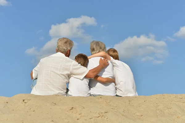 Familia sentada en la playa — Foto de Stock