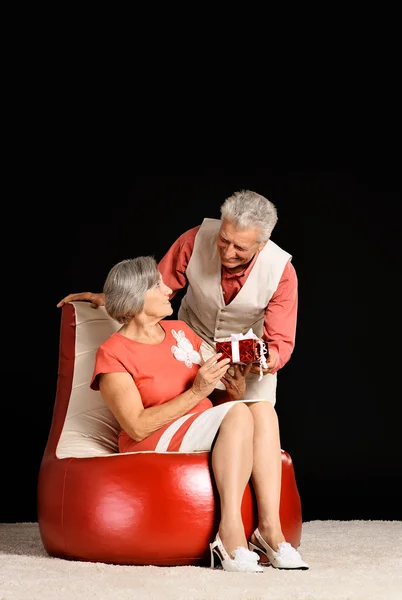 Elderly husband gives gift to his wife — Stock Photo, Image