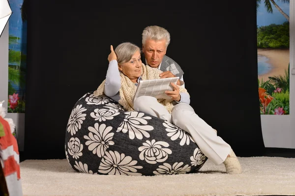 Elderly couple with newspaper — Stock Photo, Image