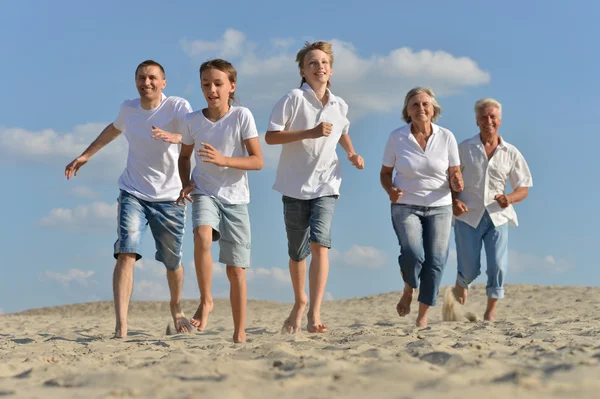 Família correndo na areia — Fotografia de Stock