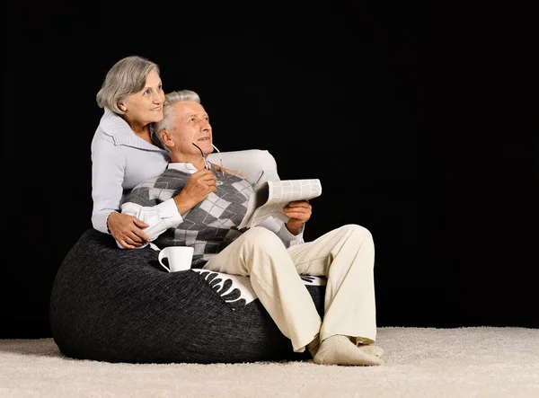 Elderly couple reading newspaper — Stock Photo, Image