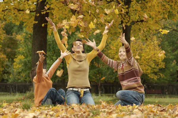 Madre con due figli nel parco autunnale — Foto Stock