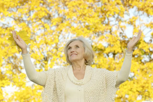 Happy senior woman in autumn park — Stock Photo, Image