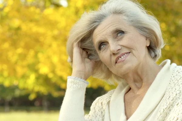 Oudere vrouw in herfstpark — Stockfoto