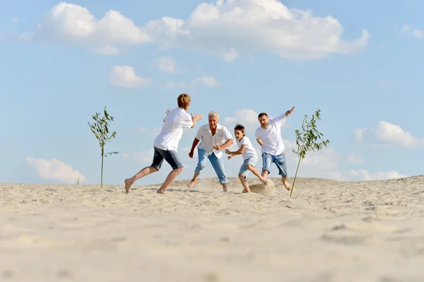 Familj spelar fotboll på stranden — Stock fotografie