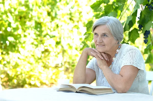 Senior woman read outdoors — Stock Photo, Image